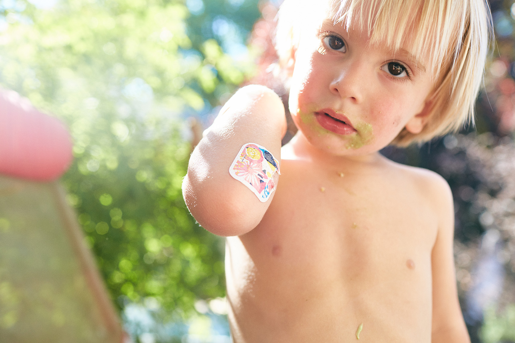 A young kiddo shows their bandaid. Lifestyle photo by Leah Verwey
