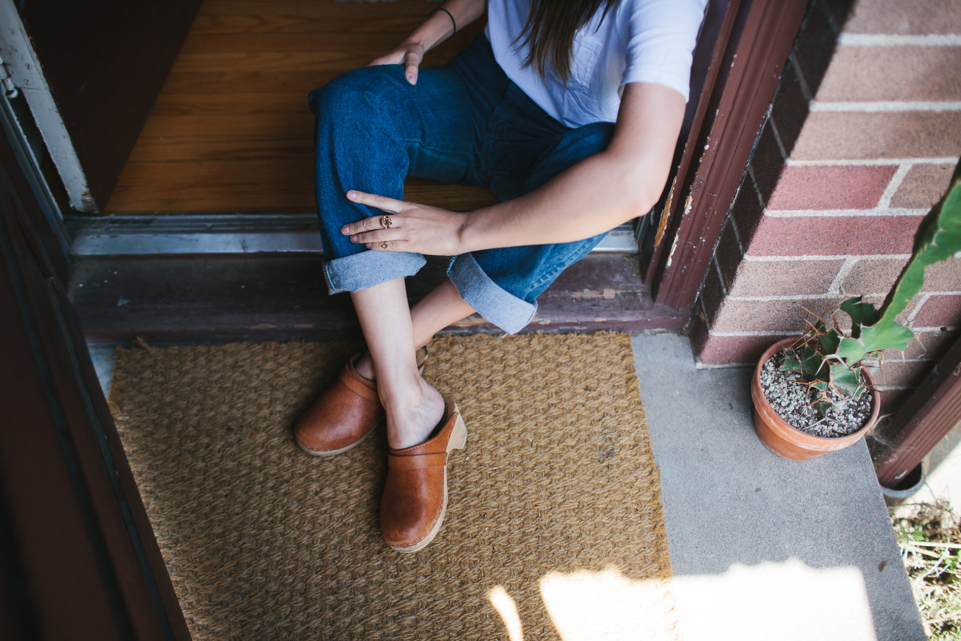 Woman in clogs relaxes on front porch - Leah Verwey 