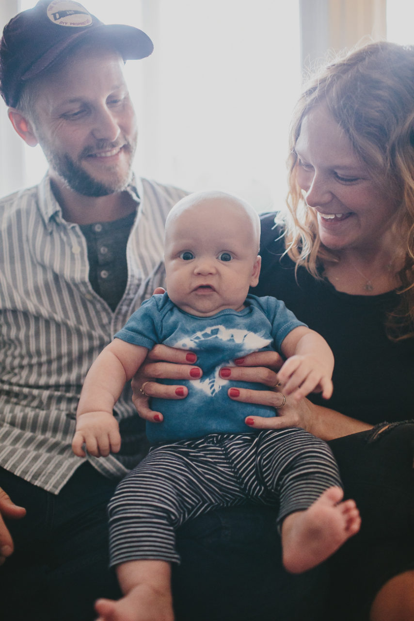 New parents snuggle their new babe in a documentary style photo - Leah Verwey