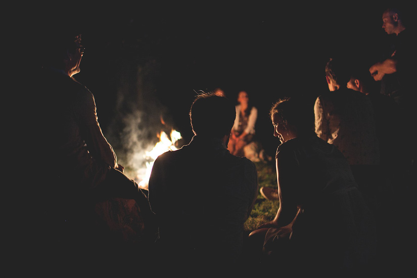 A group of people hover around a campfire - Image by Leah Verwey