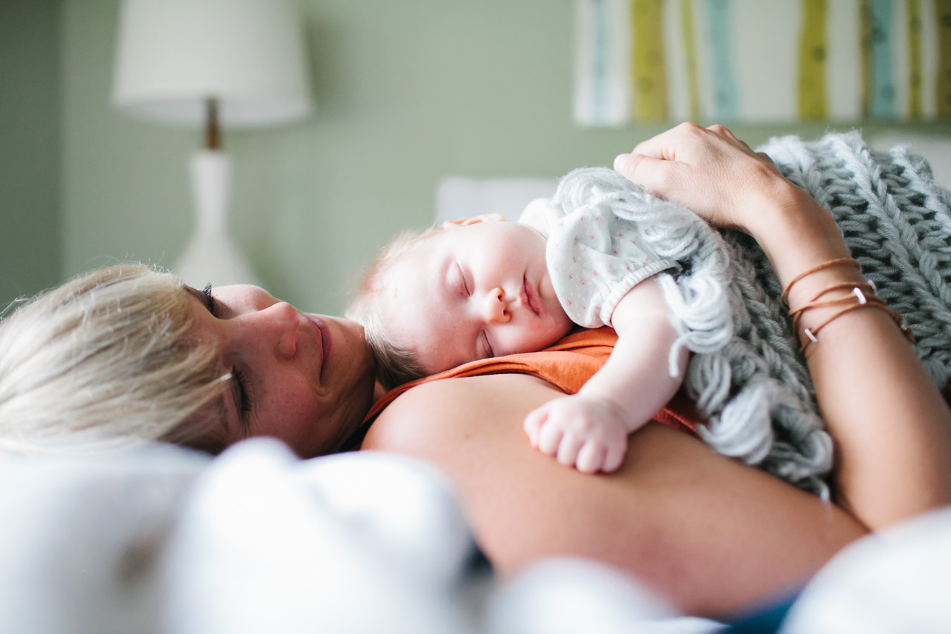A mom cuddles her baby in bed, photo by Leah Verwey.